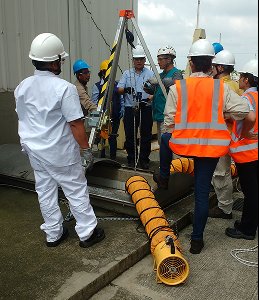 Equipo con chalecos reflectivos revisando ventilador industrial de rescate